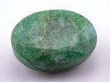 a close up of a green stone on a white surface