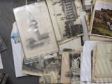 a pile of old photos and postcards on a table