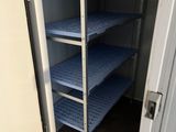 a closet with shelves and a door to a room