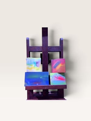 un petit chevalet en bois sur lequel sont posés plusieurs tableaux de différentes couleurs