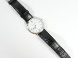 a close up of a watch on a white surface