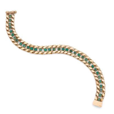 un bracelet en or orné d'émeraudes sur fond blanc