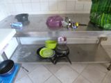 une table en acier inoxydable sur laquelle sont posés deux casseroles et poêles