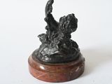 a bronze statue of a dog on a wooden base