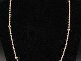 un collier à chaîne en or sur un présentoir à mannequin