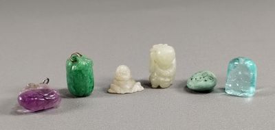 plusieurs objets en verre de différentes couleurs posés sur une surface grise
