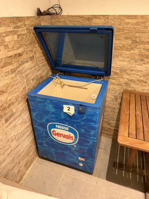 a small blue chest freezer in the corner of a room