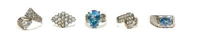 five different rings with blue stones on them on a white surface