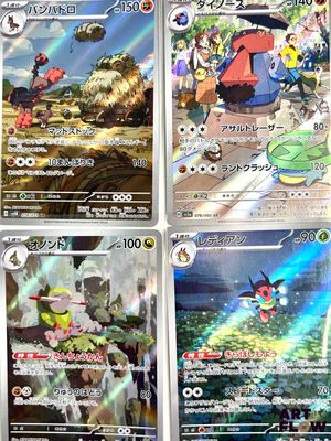 Quatre cartes Pokémon sont disposées en rangée sur une table