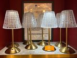 trois lampes posées sur une table, avec un tableau en arrière-plan