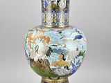 a vase with a painting on it sitting on a table