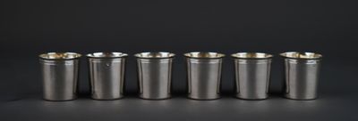 a set of six silver cups sitting on top of a table