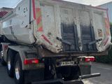 a garbage truck that is parked on the side of the road