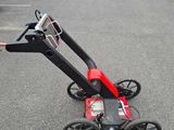 a person pushing a cart with wheels in a parking lot