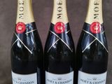 trois bouteilles de champagne posées les unes à côté des autres sur une table