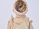 a doll that is sitting on a white surface