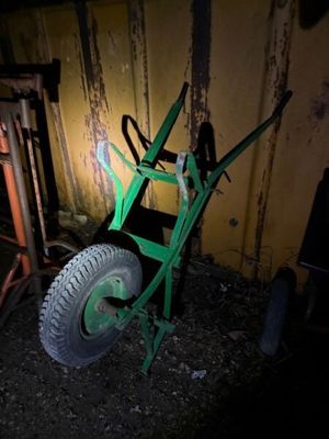 un diable vert garé sur la terre battue