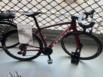 a red bike that is parked next to a fence
