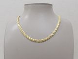 a gold chain necklace on a mannequin display stand