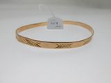a close up of a gold bracelet on a white surface