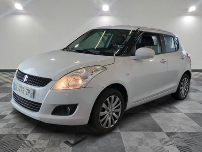 la petite voiture blanche est garée sur un carrelage à carreaux