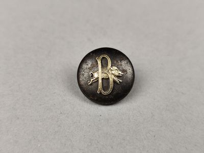un bouton noir et doré orné d'un cheval
