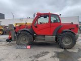 une photo d'un tracteur rouge garé sur un parking