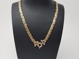un collier à chaîne en or orné d'une croix, porté par un mannequin
