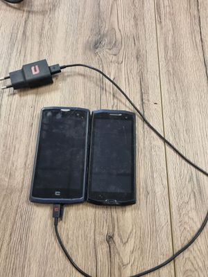 deux téléphones portables branchés à un chargeur posés sur un parquet