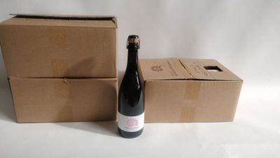 a bottle of wine sitting next to two boxes