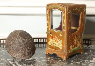 a small wooden box with a mirror and a ball on a table