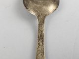 a silver spoon with a handle on a white surface
