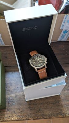 une boîte avec une montre à l'intérieur sur une table
