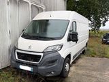 La camionnette blanche est garée devant un immeuble, à côté d'un arbre.