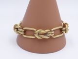 gold plated bracelet with a twisted rope design on a mannequin base