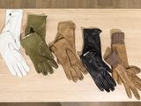 four pairs of gloves are lined up on a wooden table