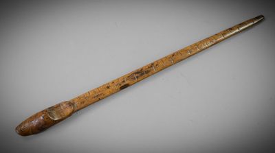 an old wooden stick with a wooden handle sitting on top of a table
