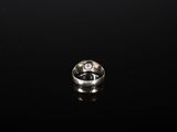 a close up of a silver ring on a black surface