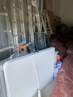 many pieces of furniture in a room with a ladder