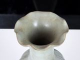 a white vase sitting on a table with a black background