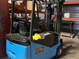 un chariot élévateur bleu garé dans un entrepôt