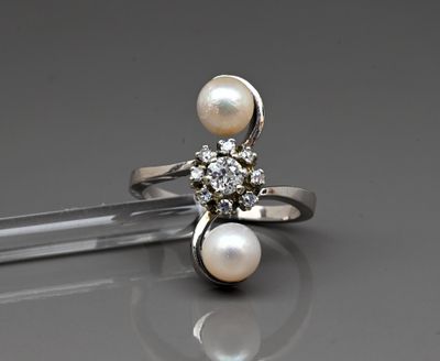 an image of a ring with pearls and diamonds on a table