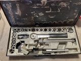 un ensemble d'outils rangés dans une boîte à outils posée par terre