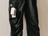 leather pants hanging on a hanger on a wall in a room