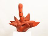 a red sculpture on a white pedestal on a white surface