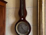 une horloge accrochée au mur à côté d'un miroir