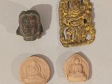 trois morceaux d'or et un petit morceau de bronze sur un fond blanc