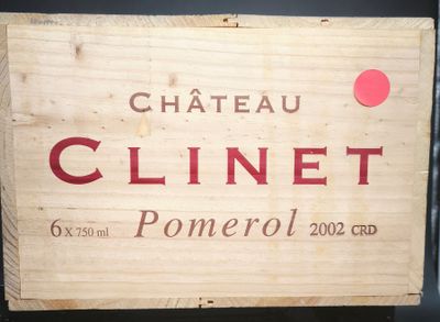 une boîte en bois sur laquelle est apposée une étiquette indiquant « Château Clinet »