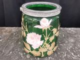 un vase vert orné de fleurs roses, posé sur une table