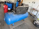 a blue air compressor sitting on a cart in a garage